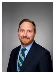 Matt Kirkland with navy blue suit and striped tie